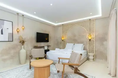 a bedroom with a bed and a table and chairs at Suite Oasis - cosy et moderne in Marrakech