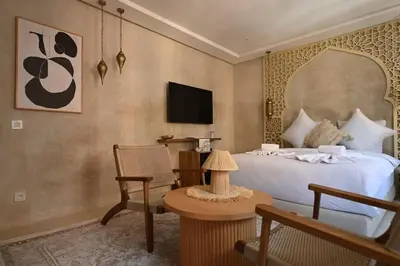 a bedroom with a large bed and a tv at Suite Oasis - cosy et moderne in Marrakech