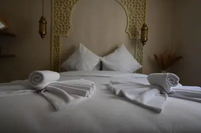 a white bed with towels and pillows on it at Suite Atlas - Douceur et confort in Marrakech