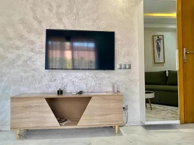 a living room with a tv on a wall at Perfect pied-à-terre 1ch in Gueliz in Marrakech