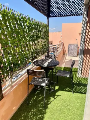 a patio with a table and chairs on a balcony at Perfect pied-à-terre 1ch in Gueliz in Marrakech
