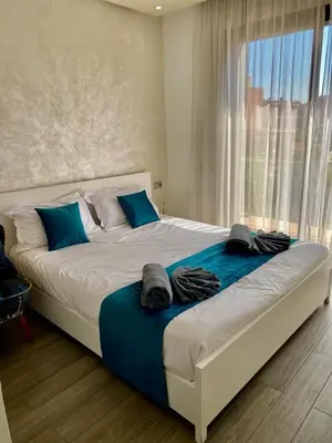 a bedroom with a large bed with blue pillows at Small 1-bedroom apartment perfect for discovering Marrakech in Marrakech