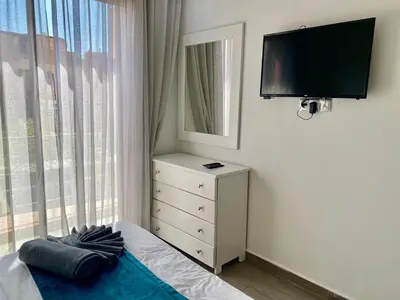 a bedroom with a bed and a dresser with a television at Small 1-bedroom apartment perfect for discovering Marrakech in Marrakech
