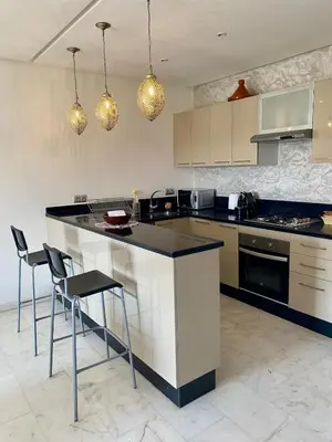 a kitchen with a counter and chairs in it at Small 1-bedroom apartment perfect for discovering Marrakech in Marrakech