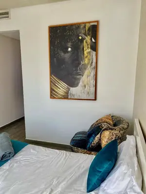 a bedroom with a bed with a painting on the wall at Small 1-bedroom apartment perfect for discovering Marrakech in Marrakech