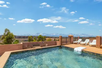 a pool with chairs and a deck with a view at City Center-1 Queen BR with AC, Pool and IPTV- Parking in Marrakech