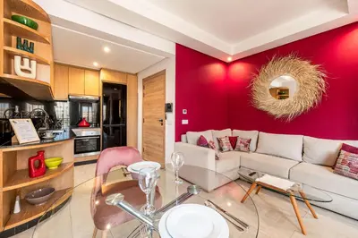 a living room with a white couch and a red wall at City Center-1 Queen BR with AC, Pool and IPTV- Parking in Marrakech
