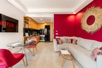 a living room with a white couch and a red wall at City Center-1 Queen BR with AC, Pool and IPTV- Parking in Marrakech