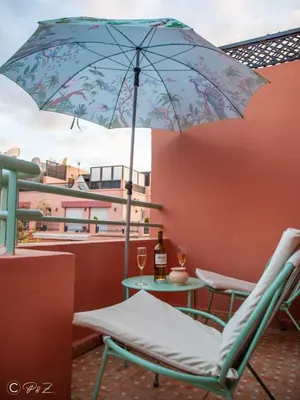 a patio with a chair and an umbrella on a balcony at Sublime 2 bedroom apartment in Marrakech in Marrakech