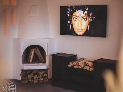 a room with a fireplace with a painting of a woman at Sublime 2 bedroom apartment in Marrakech in Marrakech