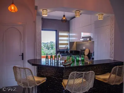 a kitchen with a bar with chairs and a counter top at Sublime 2 bedroom apartment in Marrakech in Marrakech