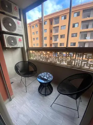 a balcony with two chairs and a table and a window at Very nice apartment on Route de Casa in Marrakech