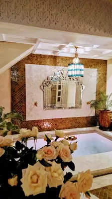a room with a swimming pool with a mirror and flowers at Dar Riad Sidi Duri en exclusivité 7 P with private Pools in Marrakech