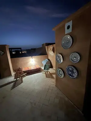 a room with plates on the wall and a couch at Duplex Le Vizir for 6 with Park Access 3 Pools in Dar Caïd Layadi