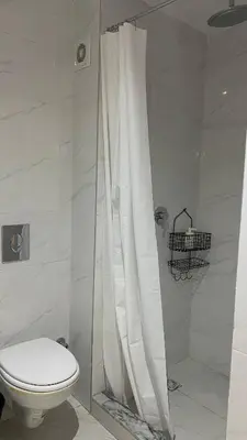 a bathroom with a toilet and a shower curtain at Moulay Youssef in Marrakech