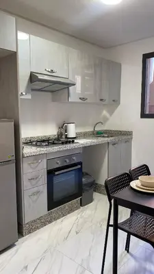 a kitchen with stainless steel appliances and a table at Moulay Youssef in Marrakech