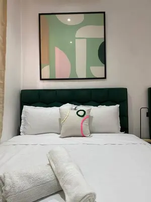 a bed with a green headboard and white pillows at Moulay Youssef in Marrakech