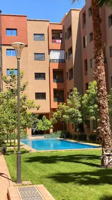 a large apartment building with a swimming pool and a street light at Moulay Youssef in Marrakech