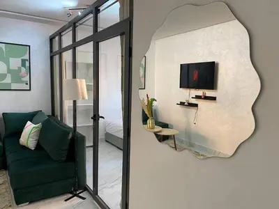a living room with a green couch and a mirror at Moulay Youssef in Marrakech