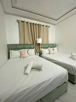 a bedroom with two beds with white sheets at Moulay Youssef in Marrakech