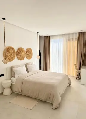 a white bedroom with a large bed and a window at Villa 289- Charme Balinais in Marrakech