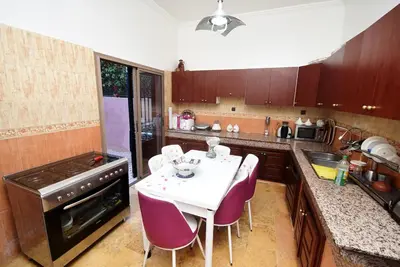 a kitchen with a white table and purple chairs at Villa Marrakech in Marrakech