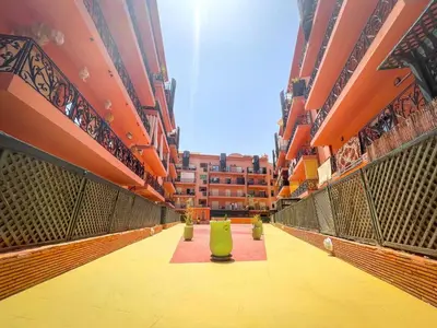 a corridor of a building with a green bench in the middle at Majorelle Cozy Apartment Garden 2-Balcony Downtown in Marrakech