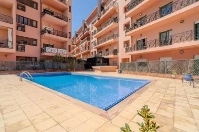 a swimming pool in front of a building at Majorelle Cozy Apartment Garden 2-Balcony Downtown in Marrakech