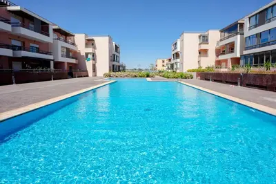 a blue swimming pool in front of some apartment buildings at L'ambiance de Marrakech Luxe in Marrakech