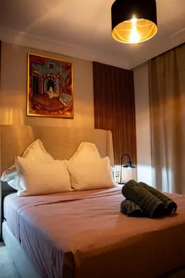 a bedroom with a large bed with a white bedspread at Hivernage, piscine & jardin privé in Marrakech