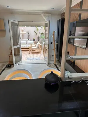 a kitchen with a counter top and a living room at MY LOCANA - Appartement Gueliz Jaccuzi in Marrakech