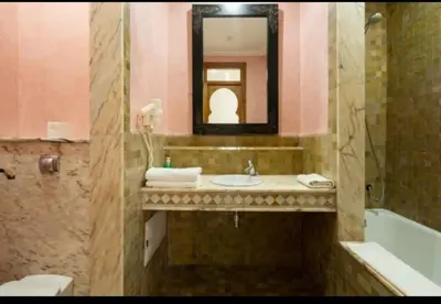 a bathroom with a sink and a tub and a mirror at Palmeraie Village 2 in Marrakech
