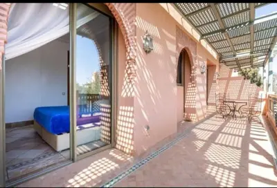 a balcony with a blue bed in a building at Palmeraie Village 2 in Marrakech