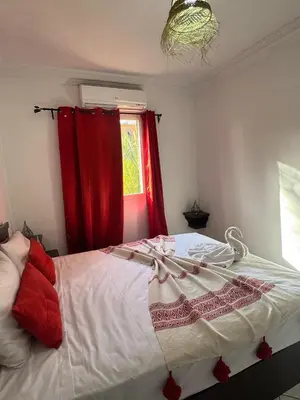 a bedroom with a bed with red curtains and a window at Riad Four Rooms & Pool in Marrakech