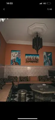 a living room with a couch and tables and pictures at Riad Four Rooms & Pool in Marrakech