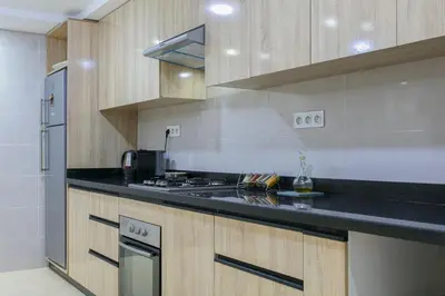 a kitchen with wooden cabinets and a black counter top at Villa Sérénité Marrakech in Marrakech