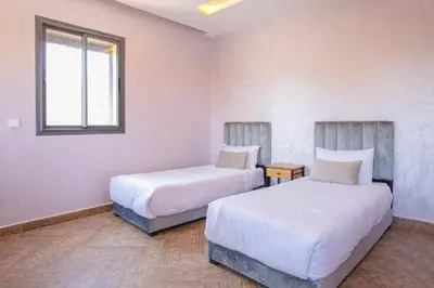 a bedroom with two beds and a window at Villa Sérénité Marrakech in Marrakech