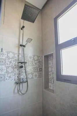 a shower with a shower head in a bathroom at Villa Sérénité Marrakech in Marrakech