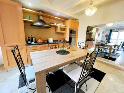 a kitchen and dining room with a wooden table and chairs at perle studio familial in Marrakech