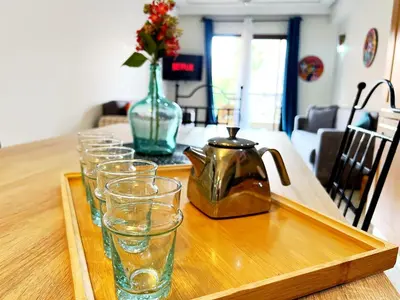 a wooden table with glasses and a tea kettle on it at perle studio familial in Marrakech