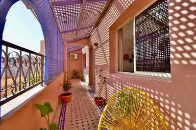 a balcony with a purple wall and potted plants at Appartement Les Huit Palmiers in Marrakech
