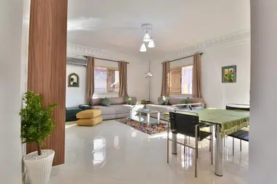 a living room with a table and a couch at Appartement Les Huit Palmiers in Marrakech