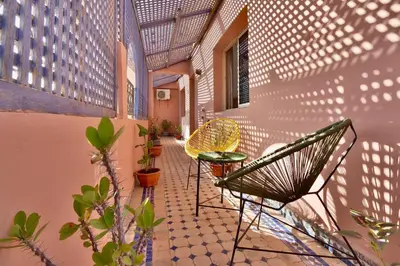 a patio with two chairs and a table on a building at Appartement Les Huit Palmiers in Marrakech