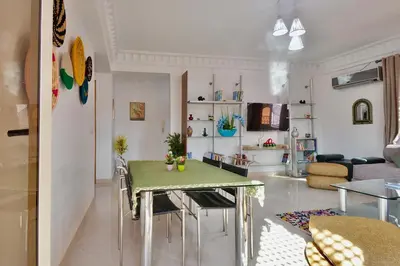 a kitchen and living room with a table and chairs at Appartement Les Huit Palmiers in Marrakech