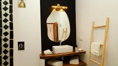 a bathroom with a sink and a large mirror at Riad Reflet D'orient Marrakech in Marrakech