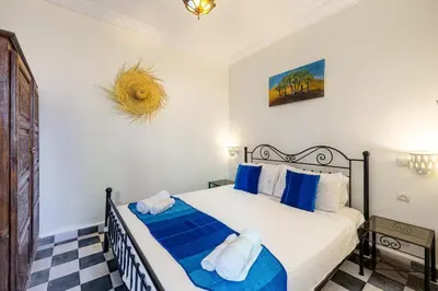 a bedroom with a bed with blue and white sheets at 2BR Medina Home with Roof Terrace in Marrakech