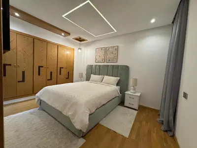 a bedroom with a large bed and wooden cabinets at Luxury Retreat 2Bdr Appartment In Prime Marrakech in Marrakech