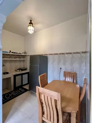a kitchen with a table and chairs and a refrigerator at Apartment with rooftop access in Marrakech