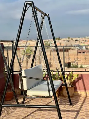 a swing chair on a balcony with a view at Apartment with rooftop access in Marrakech