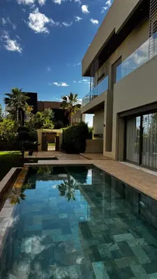 a swimming pool in front of a house at VILLA Zamzam in Marrakech